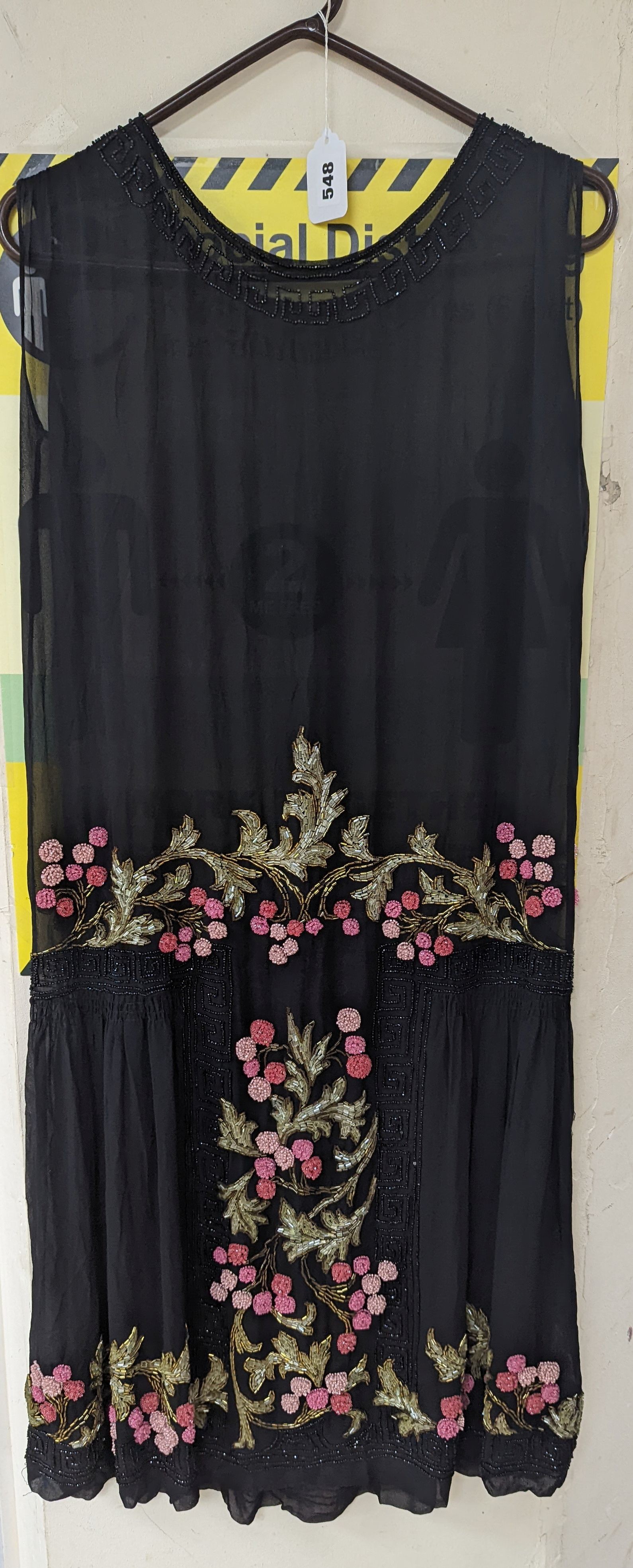 A an unusual 1920's black , georgette, beaded dress, embroidered with multicoloured and jet beads, in a floral design.